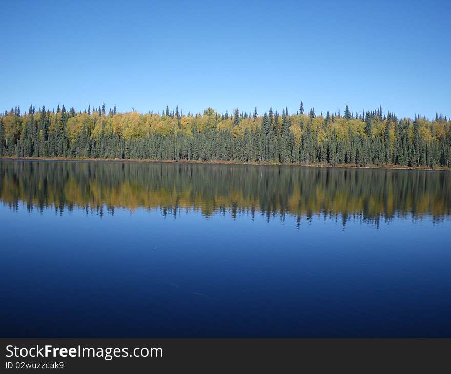 A remote lake on a fall Alaska day. There was no wind and the reflections are outstanding. A remote lake on a fall Alaska day. There was no wind and the reflections are outstanding.