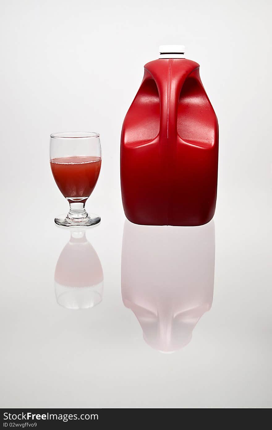 A reflection of a red punch bottle and glass of juice. A reflection of a red punch bottle and glass of juice.