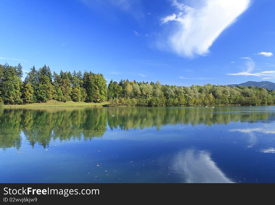 Blue lake with colorful wood and blue sky in autumn. Blue lake with colorful wood and blue sky in autumn