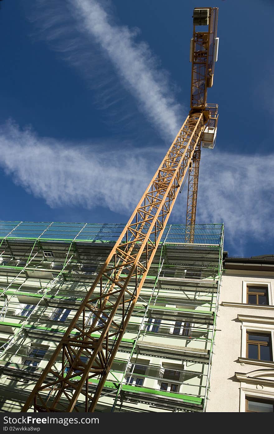 Hoisting crane on the project site with the sky background