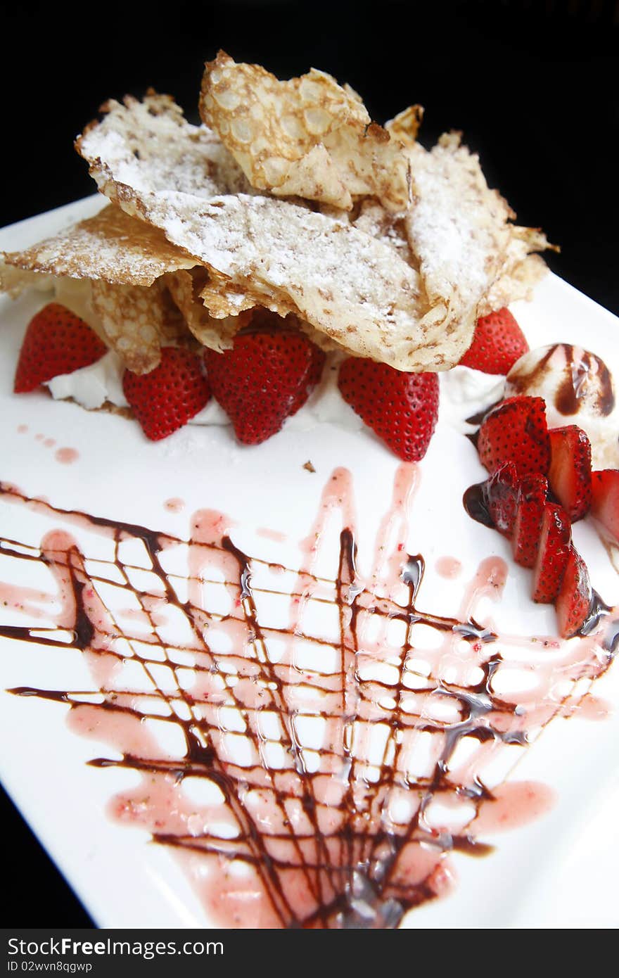 Crepe with strawberry and ice cream on the dish.