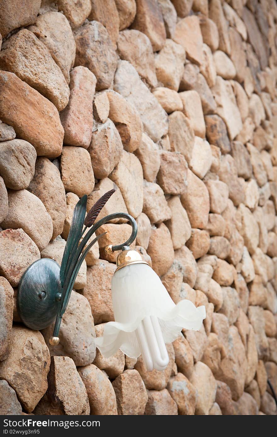 Wall lamp on stone wall background