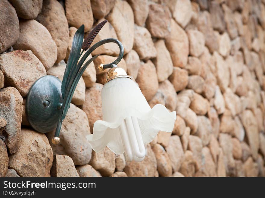 Wall lamp on stone wall background