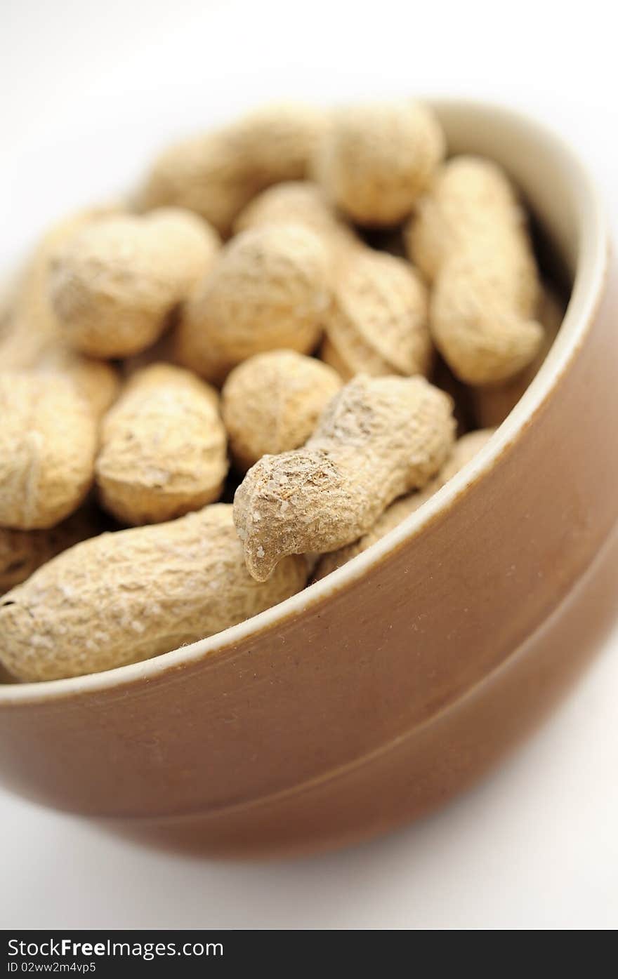 A cup of peanuts on white