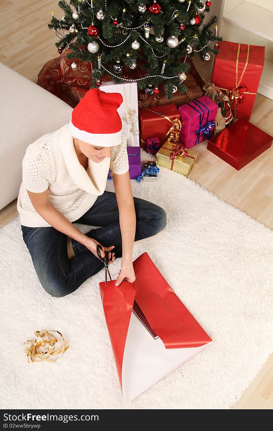 Blond woman sitting on the floor with a christmas gift