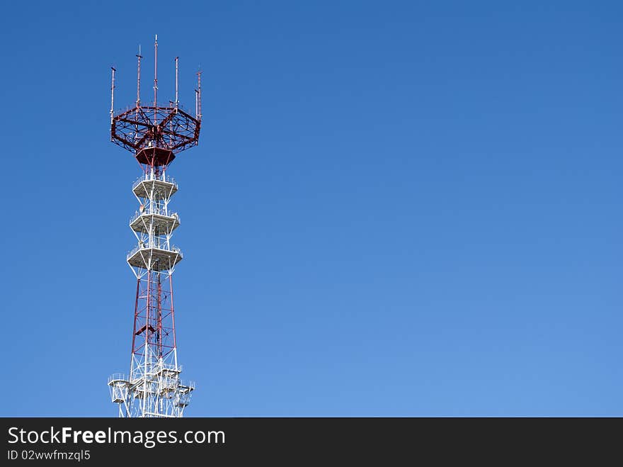 Telecommunication radio television tower high on a blue background sky. Telecommunication radio television tower high on a blue background sky