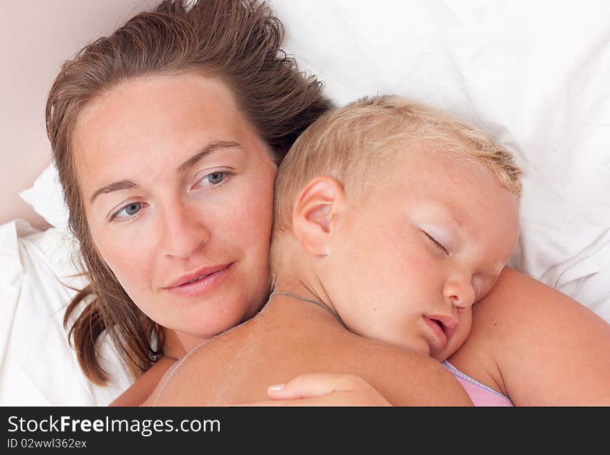 Mother and little son lying on bed