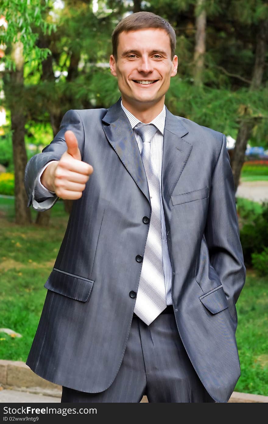 Portrait of young businessman with thumb up