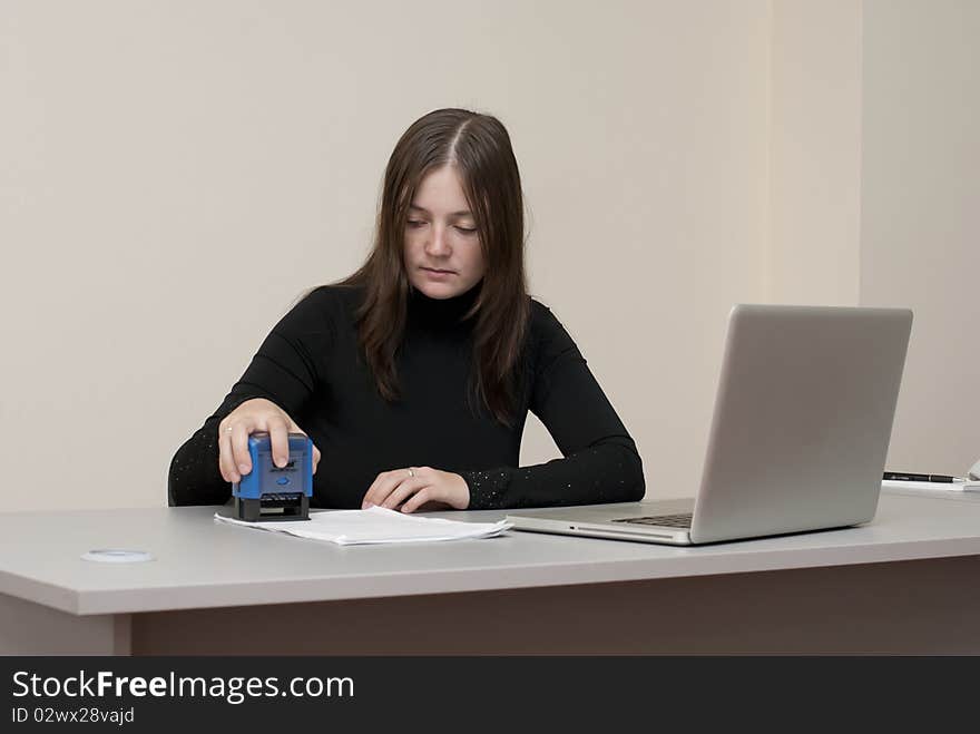 Business woman with laptop and stamp in office