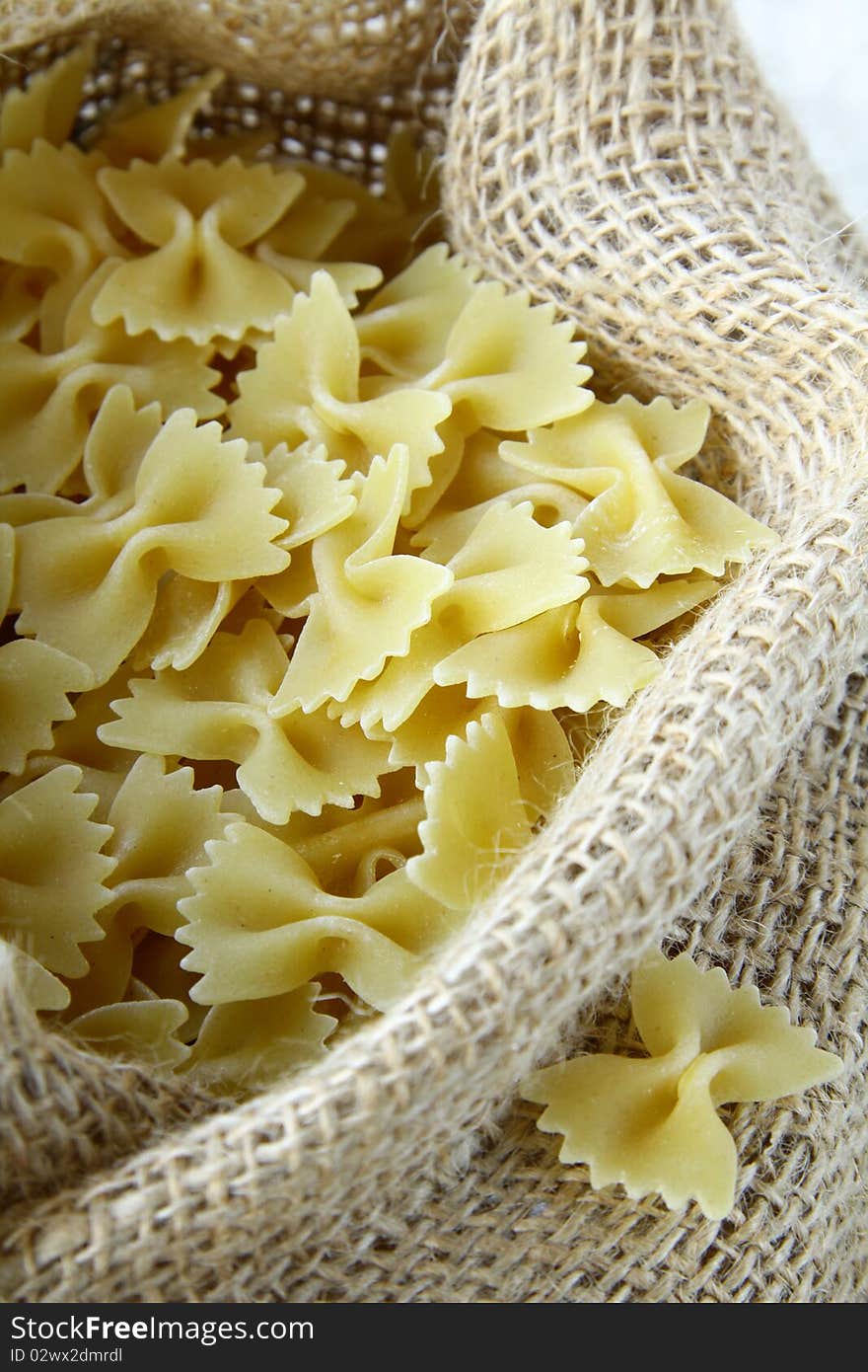 A lot of pasta in a bag on a wooden table