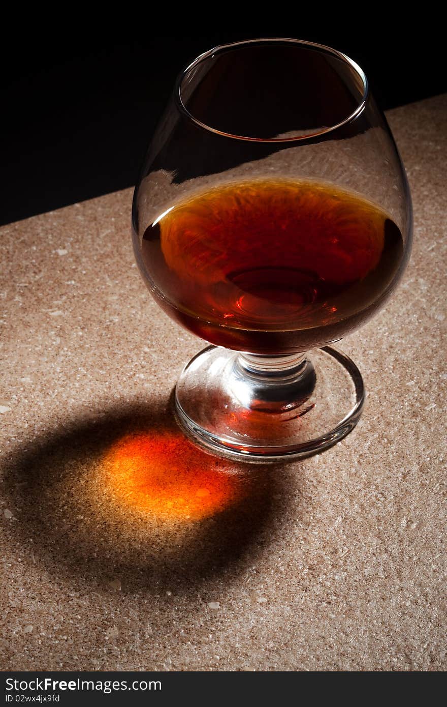 A glass of brandy on the marble table