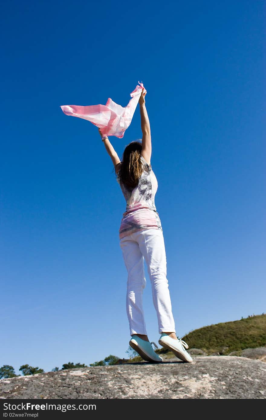 Happy young lady playing with her scarf near the sea, in the wind. Happy young lady playing with her scarf near the sea, in the wind