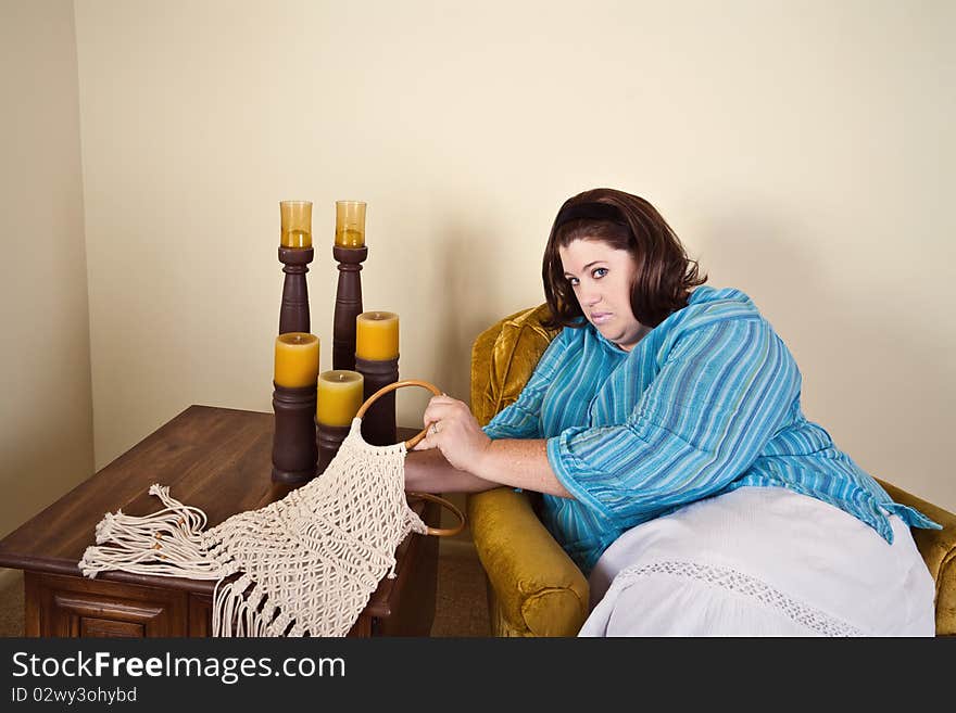 A woman looks into her macrame purse.  Sitting in a 1970's decor home with 1970's era clothing. A woman looks into her macrame purse.  Sitting in a 1970's decor home with 1970's era clothing.