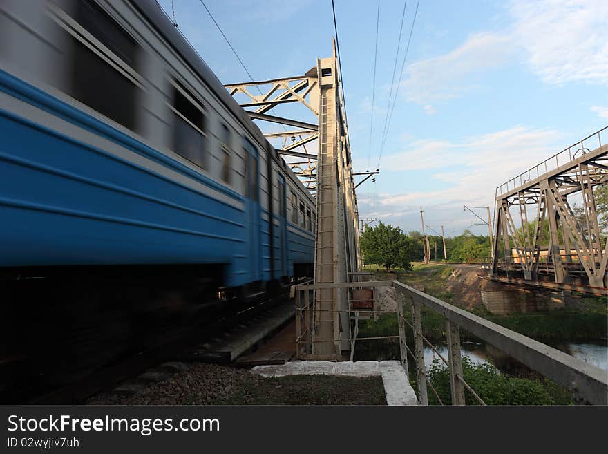 A passenger train ride over a bridge. A passenger train ride over a bridge