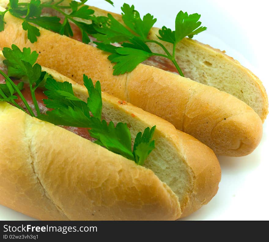 Two beautiful appetizing hot dogs decorated with parsley greens. Two beautiful appetizing hot dogs decorated with parsley greens