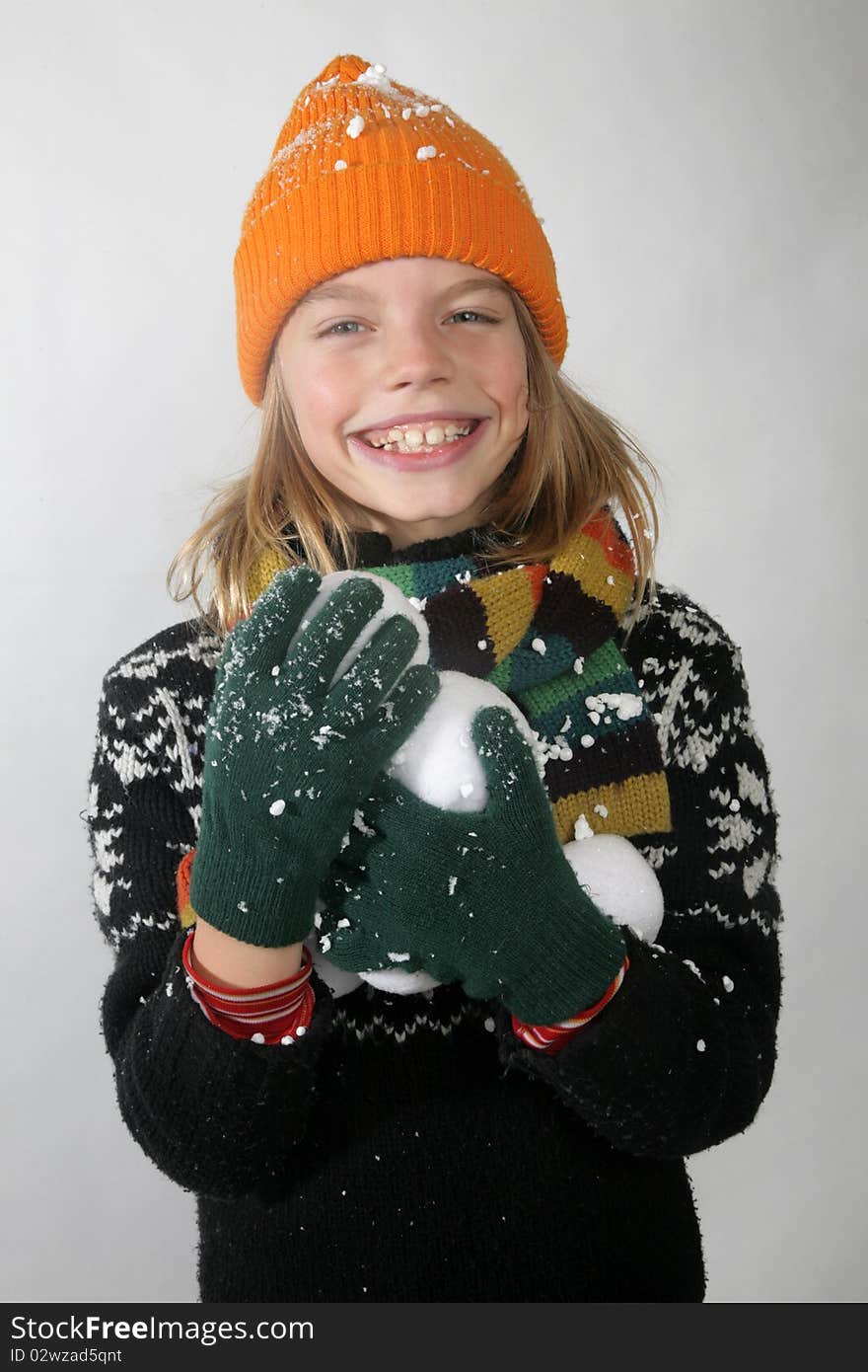 Young boy with glove bonnet and scarf holding snowball. Young boy with glove bonnet and scarf holding snowball