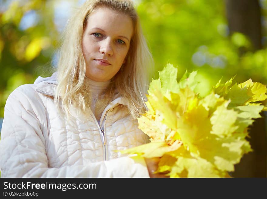 Beautiful blonde with a bouquet maple leaves