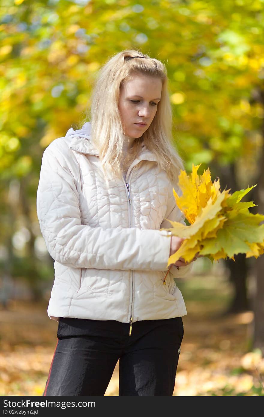 Girl Is Standing And Holding A Yellow Maple Leaves