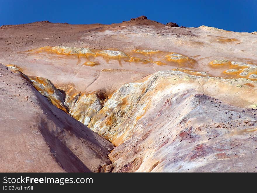 Upstream of sulfur near fumaroles with blue sky. Upstream of sulfur near fumaroles with blue sky