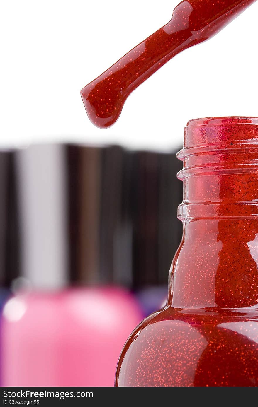 Open red nail polish bottle with a brush.