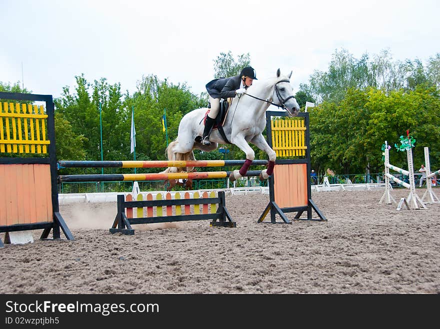 Jockey jumps over a hurdle at the competition