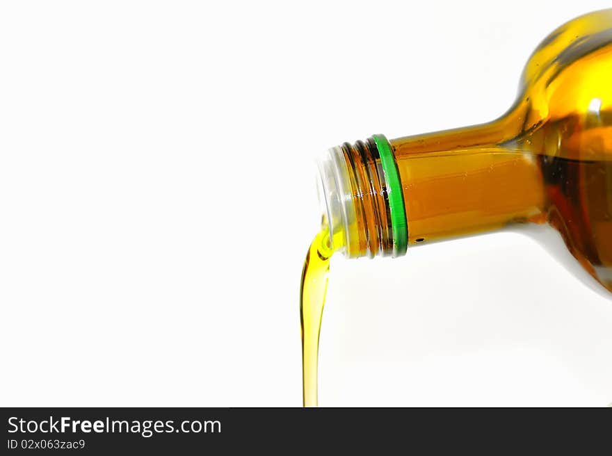 Olive Oil pouring from a bottle isolated on white