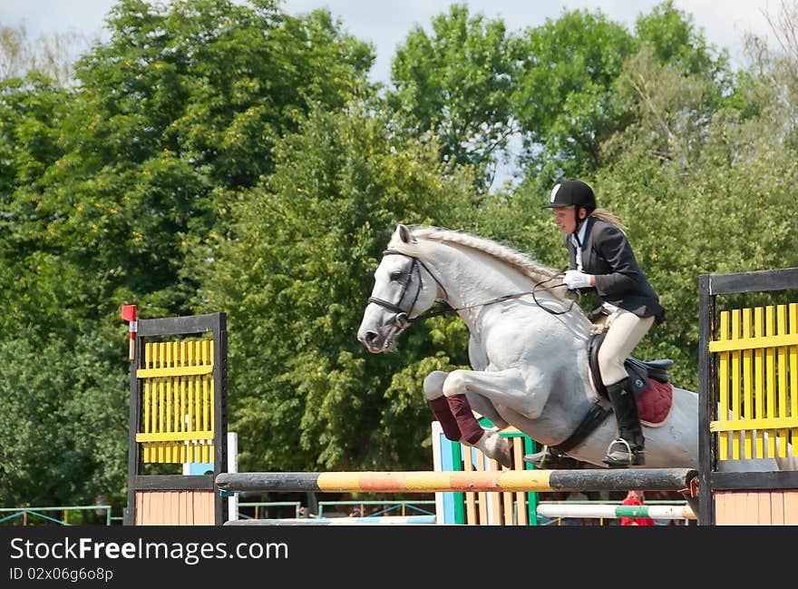 Jockey jumps over a hurdle at the competition