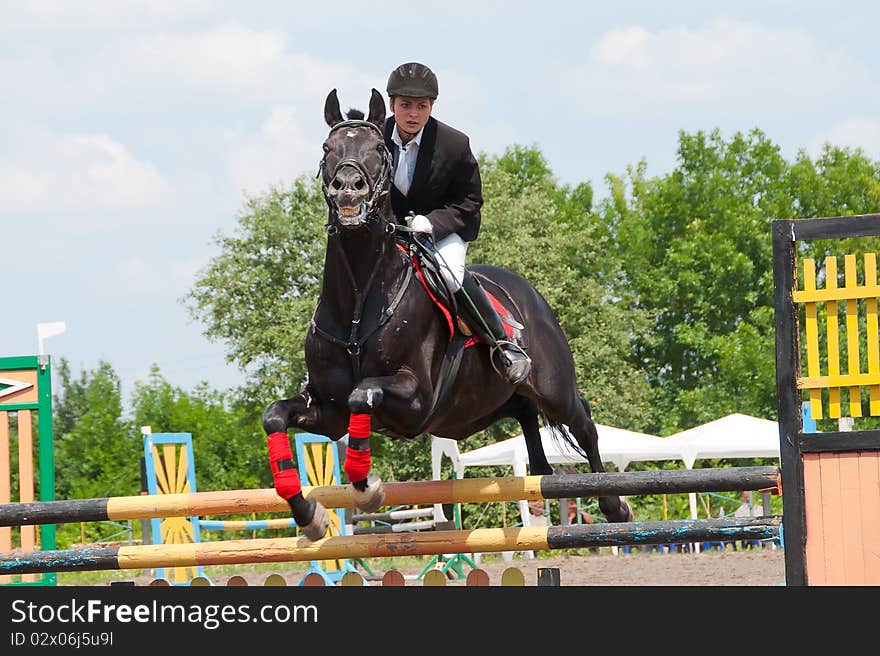 Jockey jumps over a hurdle at the competition