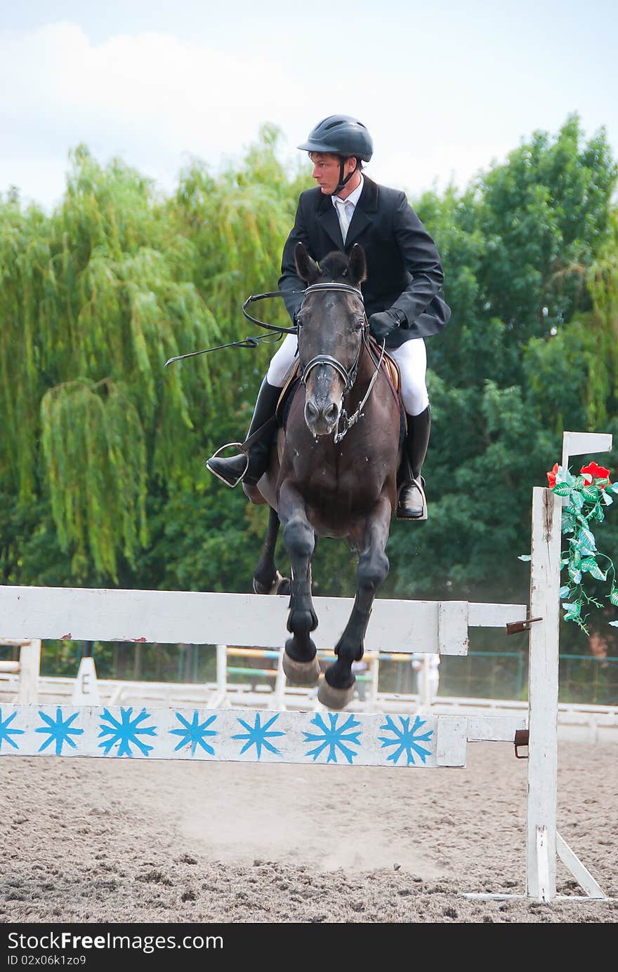 Jockey jumps over a hurdle at the competition