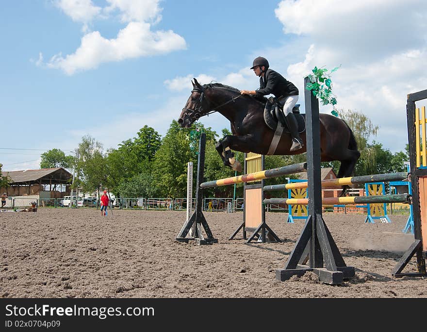 Jockey jumps over a hurdle at the competition