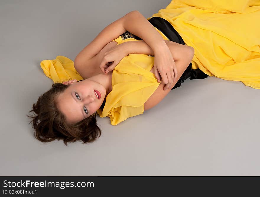 A girl an a yellow dress lying on the floor. A girl an a yellow dress lying on the floor