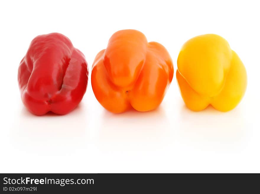 Fresh appetizing bell peppers of red, orange and yellow colors isolated on white with shadow. Fresh appetizing bell peppers of red, orange and yellow colors isolated on white with shadow