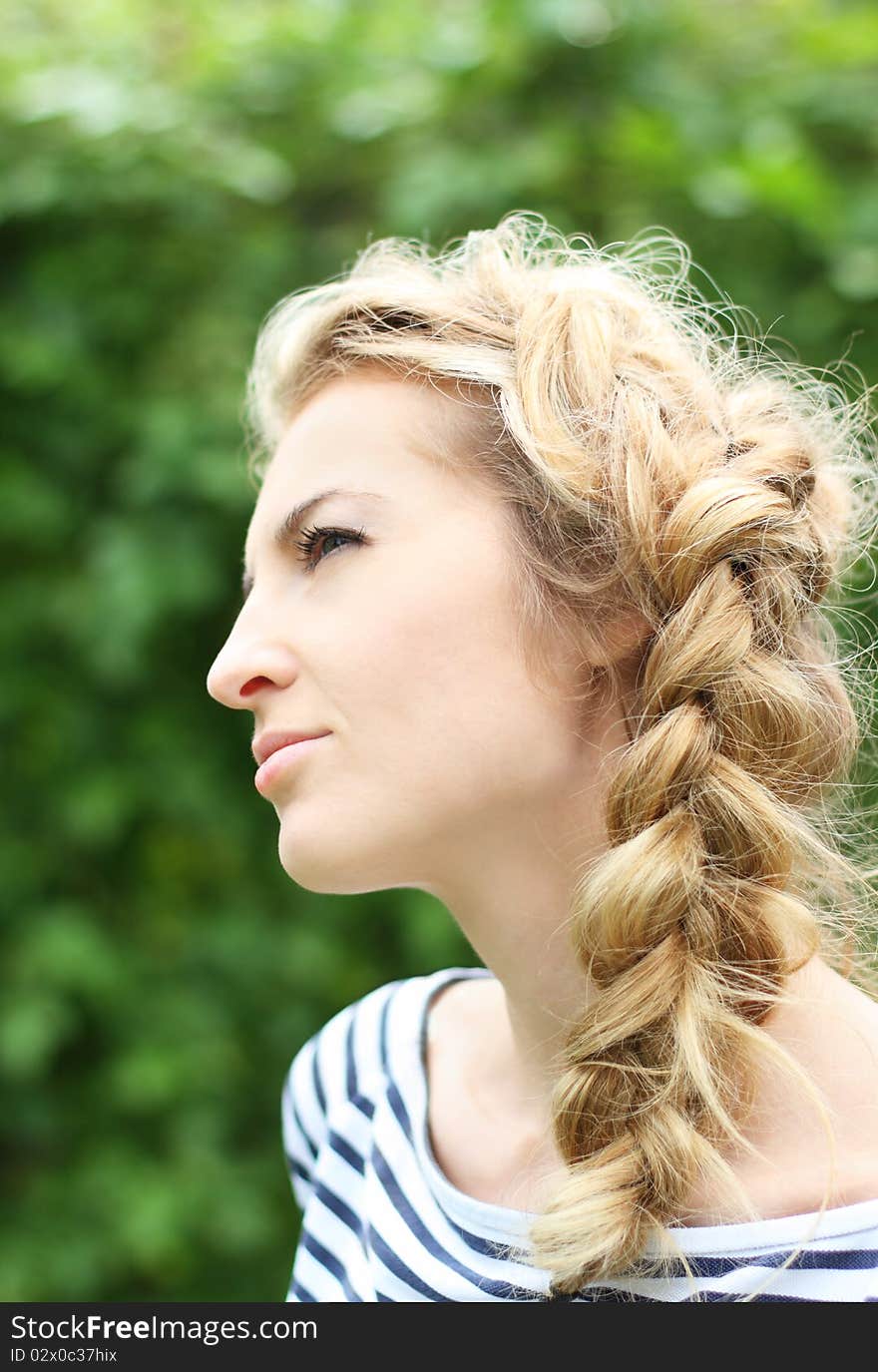 Attractive blond girl with hairdress in the garden