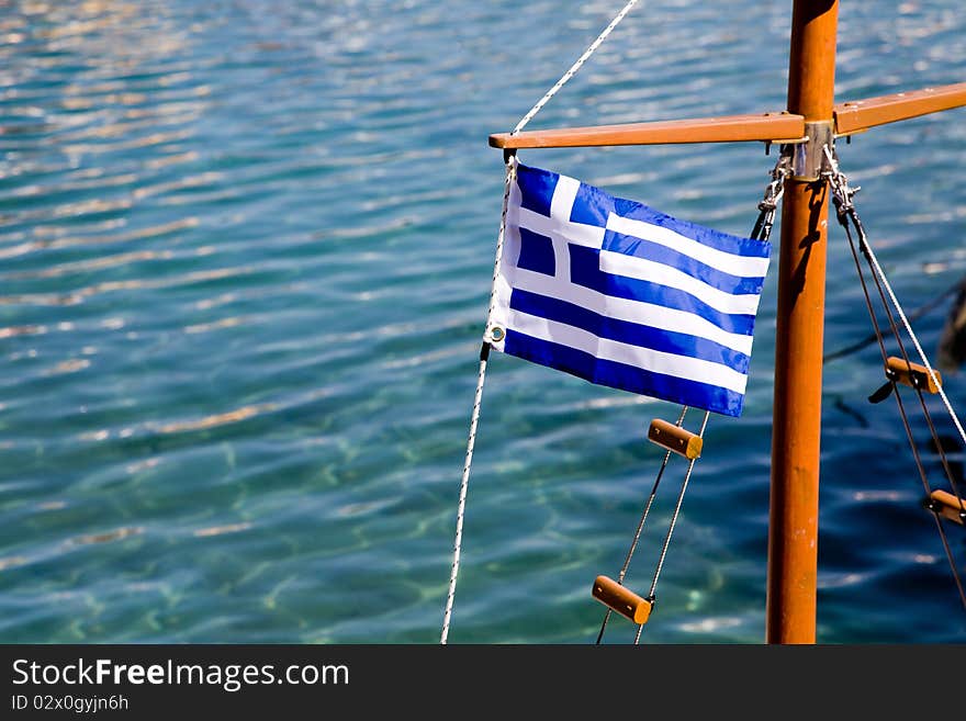 The Flag of Greece on a boat in the harbor of a Greek island. The Flag of Greece on a boat in the harbor of a Greek island.