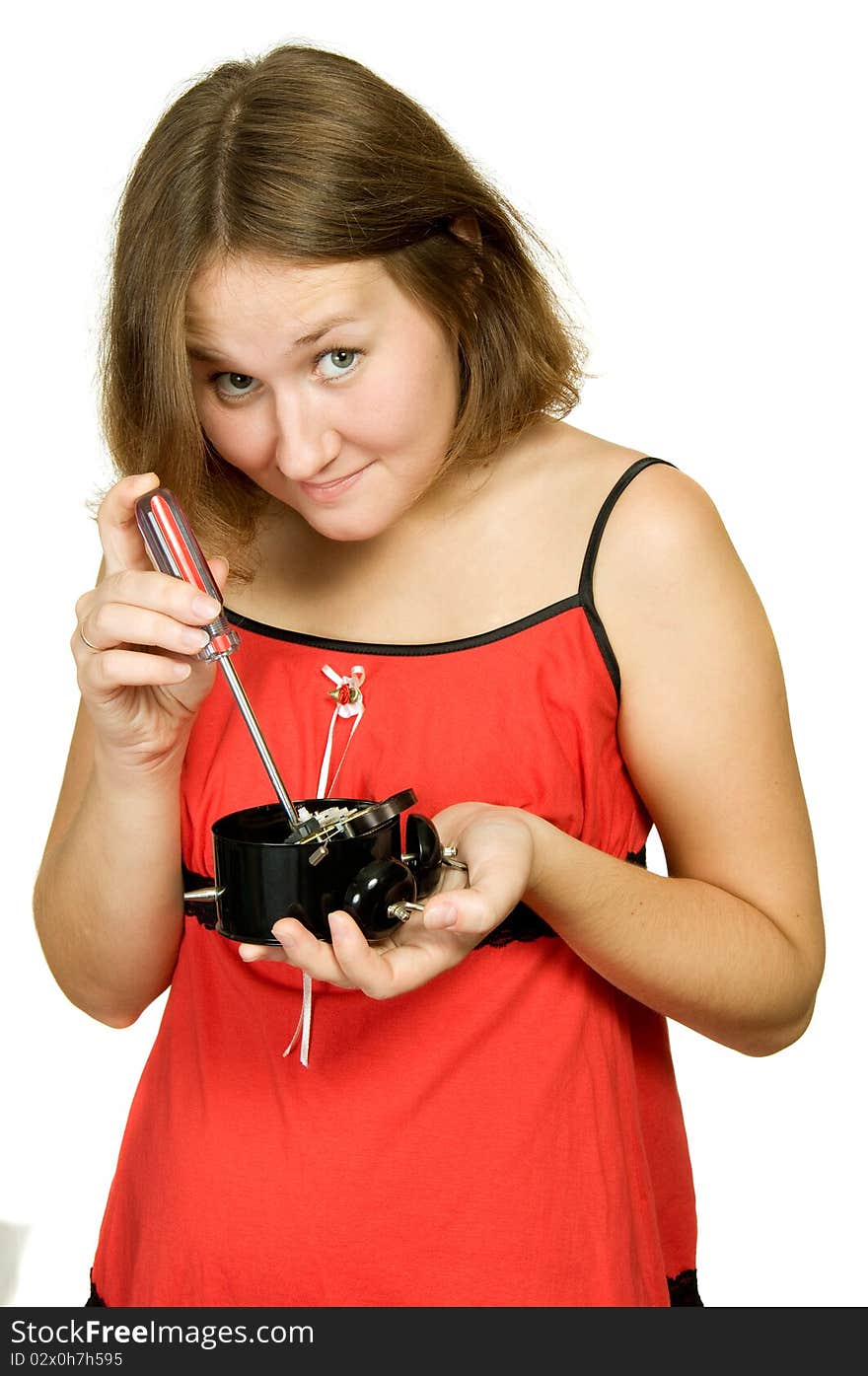 Young woman is repairing broken alarm-clock. Young woman is repairing broken alarm-clock