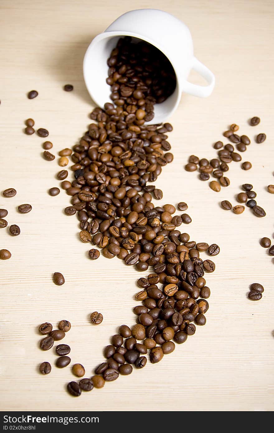 Coffee cup with coffee beans inside and falling out. Coffee cup with coffee beans inside and falling out