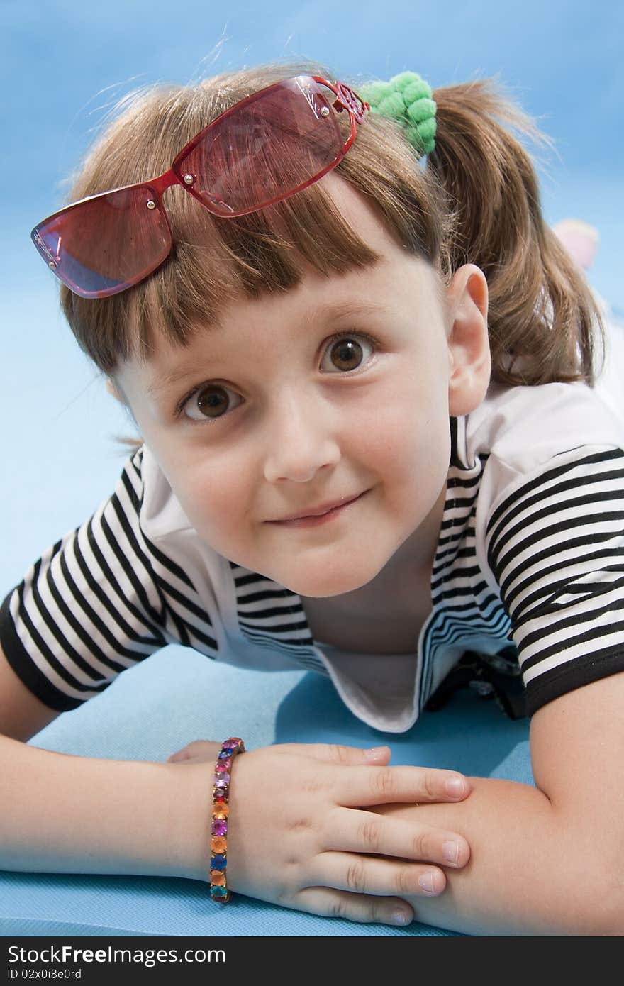 Little girl to the Lying Down on a blue background. Little girl to the Lying Down on a blue background.