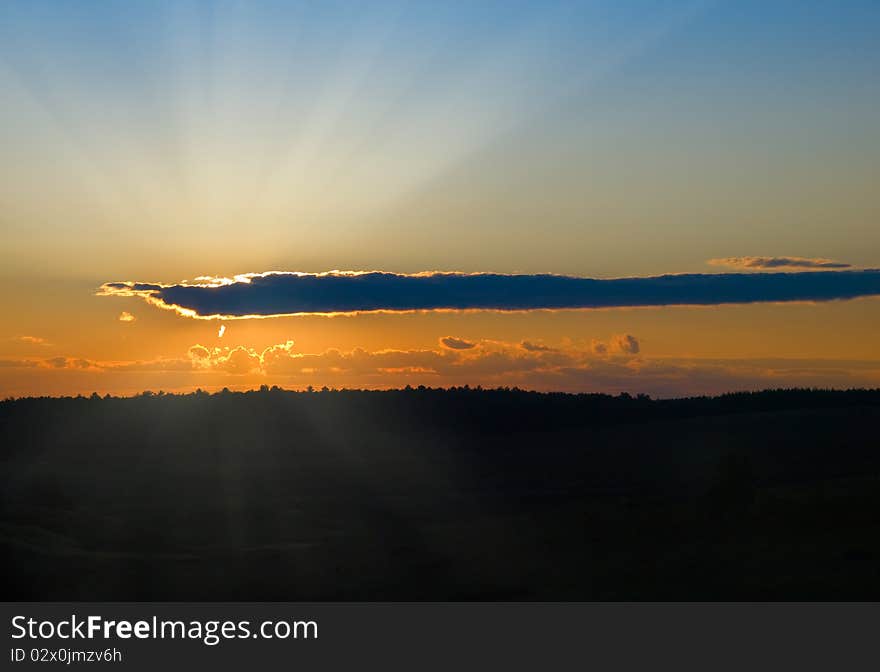 Sunset with dark cloud over meadow landscape. Sunset with dark cloud over meadow landscape