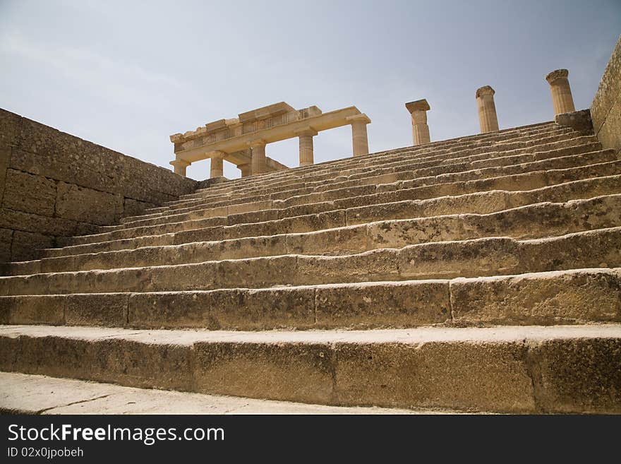 Close-up of the main stairs and what remains of the doric columns of the Acropolis of Lindos, on the Greek island of Rhodes. Close-up of the main stairs and what remains of the doric columns of the Acropolis of Lindos, on the Greek island of Rhodes.