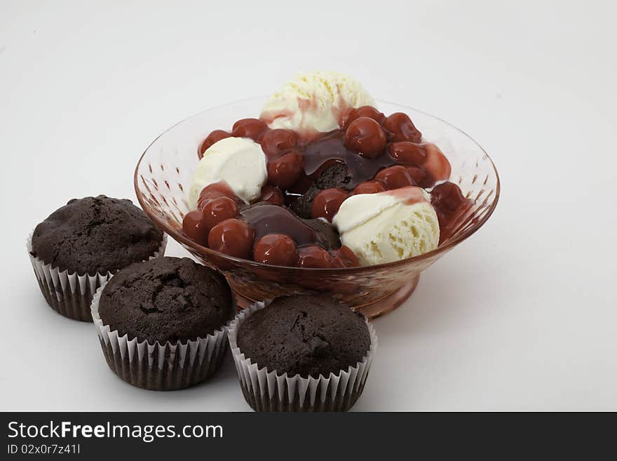 Chocolate cupcakes with chunks of chocolate in a bowl with vanilla ice cream and cherries. Chocolate cupcakes with chunks of chocolate in a bowl with vanilla ice cream and cherries.