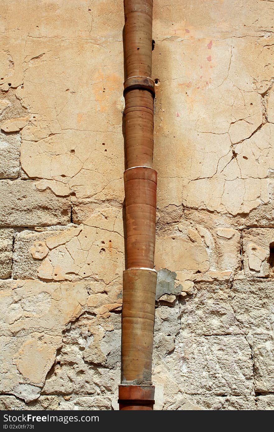 Ceramic pipe against a plastered wall