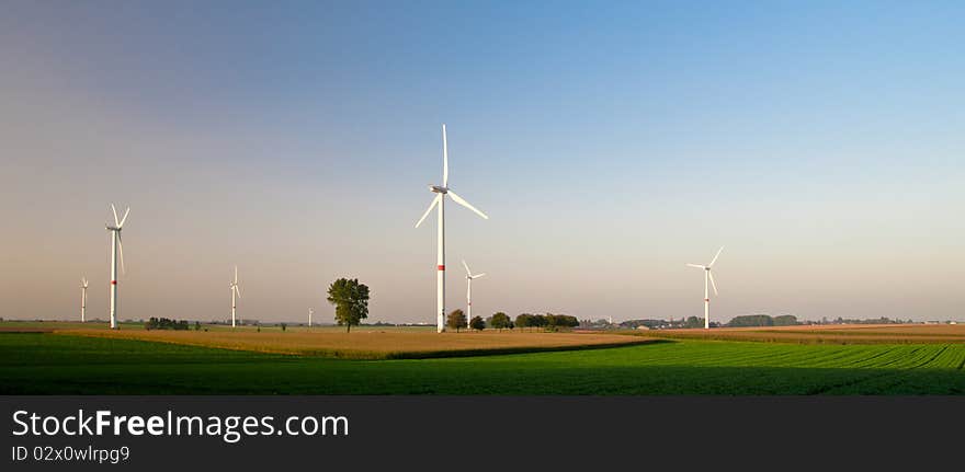 Wind turbines standing in ready to harvest fields. Wind turbines standing in ready to harvest fields