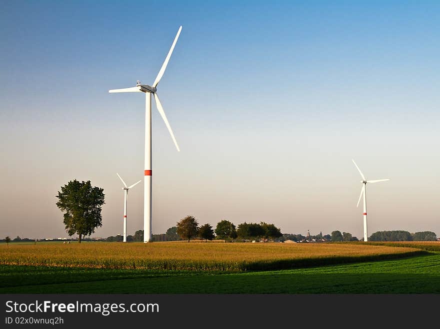 Wind turbines standing in ready to harvest fields. Wind turbines standing in ready to harvest fields