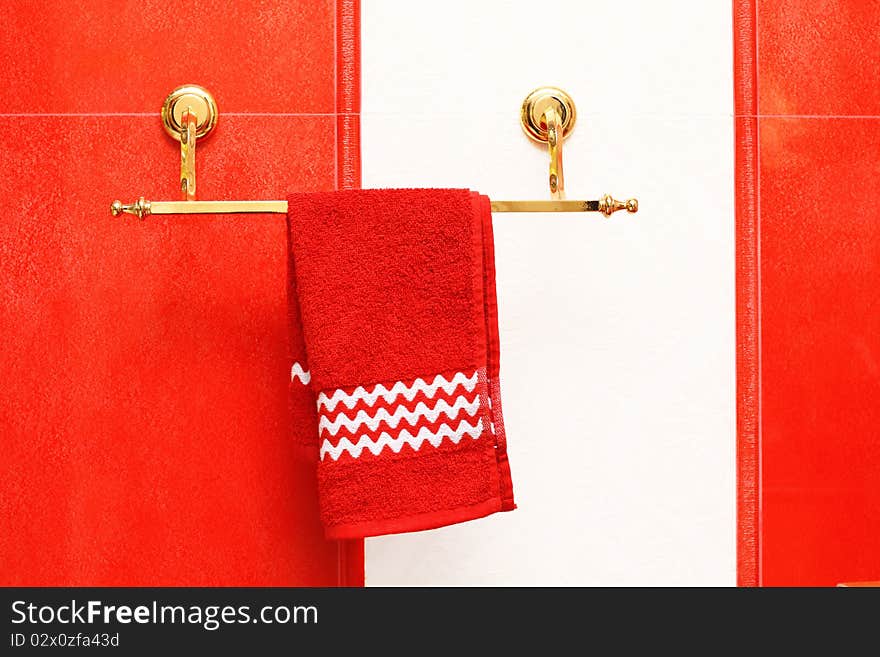 Red towel and a ceramic tile. Interior of a modern bathroom - detail