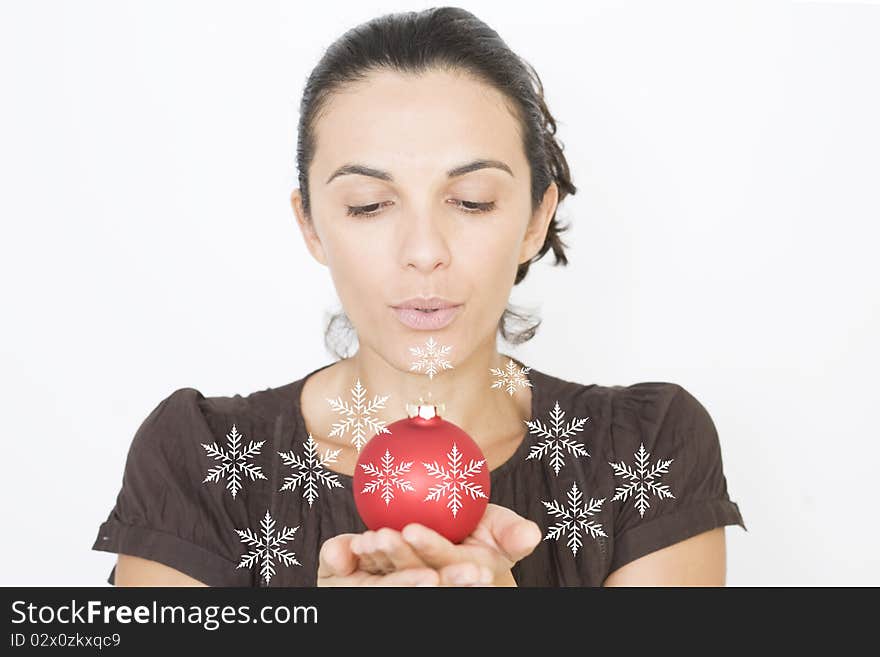 X-mas woman blowing on a red glass beads on Christmas. X-mas woman blowing on a red glass beads on Christmas