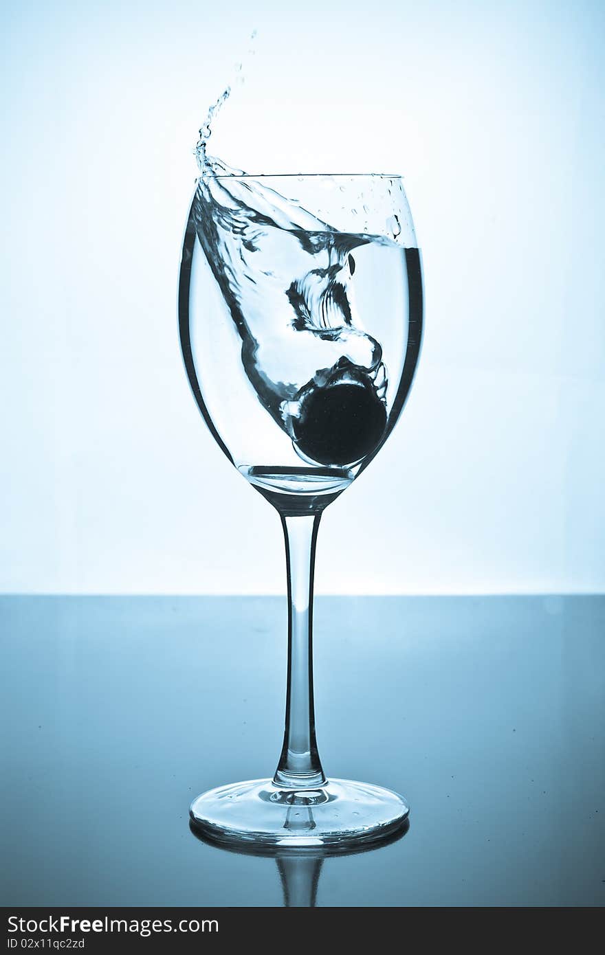 Splash of water and coins in a glass