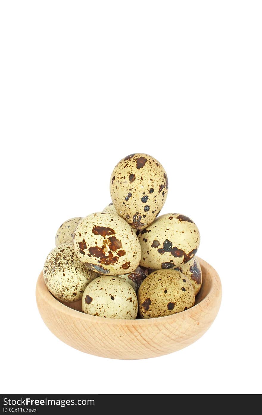 Eggs of japanese quail in wooden bowl isolated on white