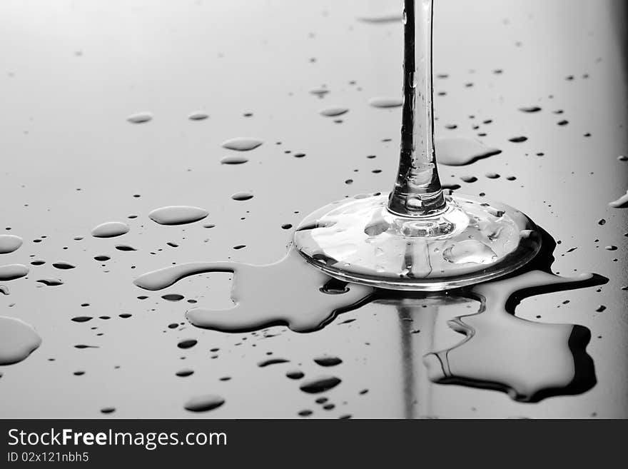 Foot of a glass surrounded by water spatters