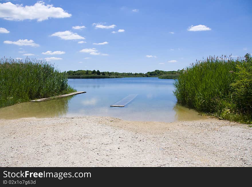 Summer landscape of pond with blue sky