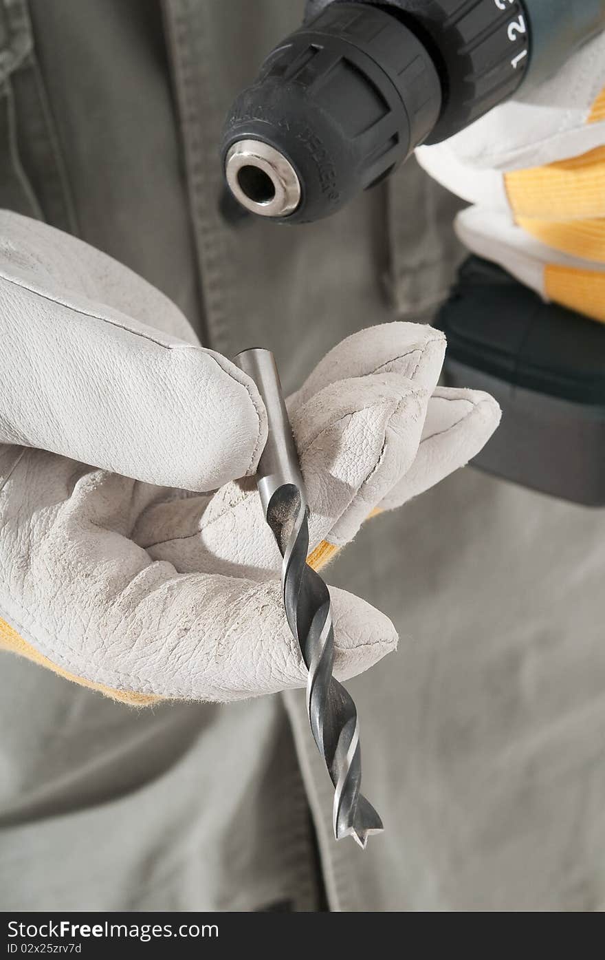 Man changing drill bit, with a gloves